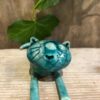 foto di un gattino in ceramica raku sdraiato color verde turchese