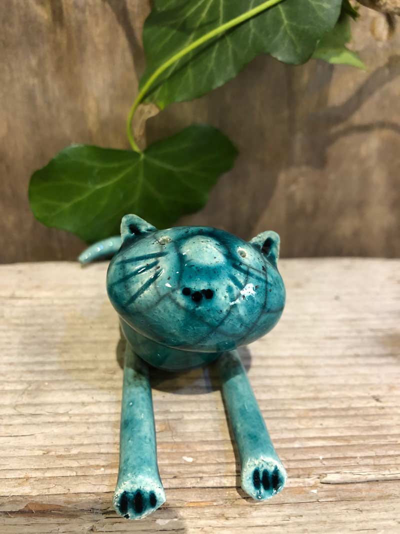 foto di un gattino in ceramica raku sdraiato color verde turchese